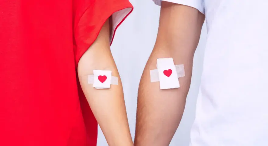 Dwie ręce z plastrami w kształcie serca. To symbol wsparcia dla krwiodawców i przypomnienie o zniżkach dla krwiodawców.