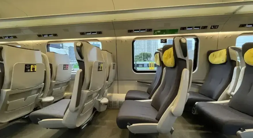 Wnętrze pociągu z wygodnymi fotelami. Czy EIP to Pendolino? Tak, to nowoczesne wagony klasy pierwszej.