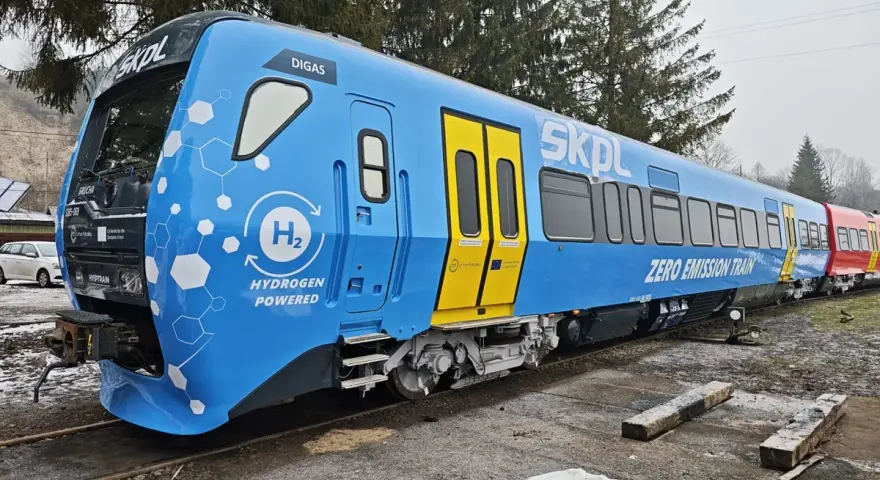 Niebieski pociąg SKPL z napędem wodorowym, oznaczony jako "ZERO EMISSION TRAIN", stoi na torach.
