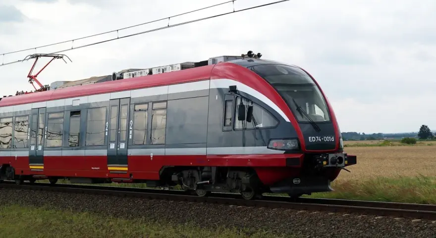 Nowoczesny pociąg PKP, idealny do sprawdzenia pkp busko-zdrój rozkład jazdy. Pędzi przez pola.