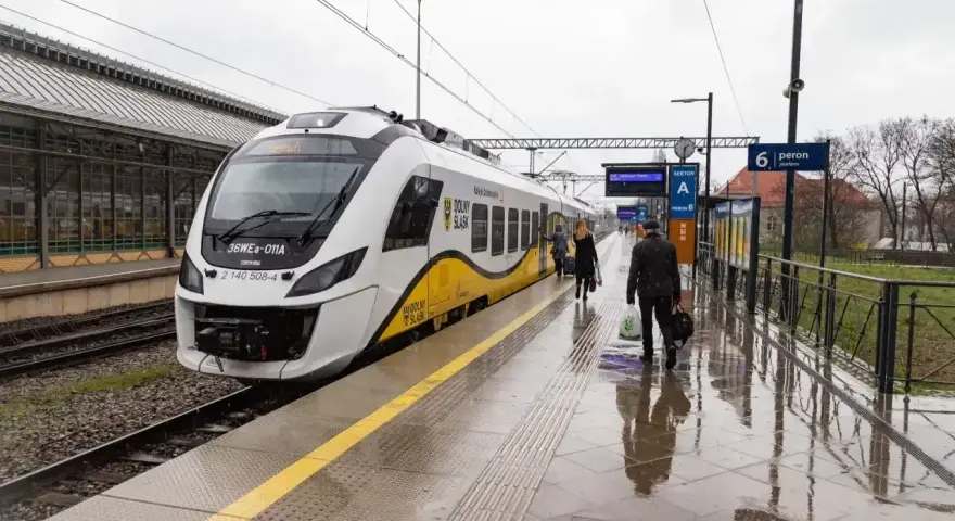 Nowoczesna hulajnoga elektryczna czeka na podróż w pociągu na mokrym peronie.