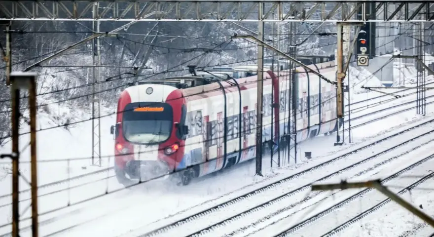 Pociąg w śniegu, mimo strajku maszynistów, jedzie po torach.