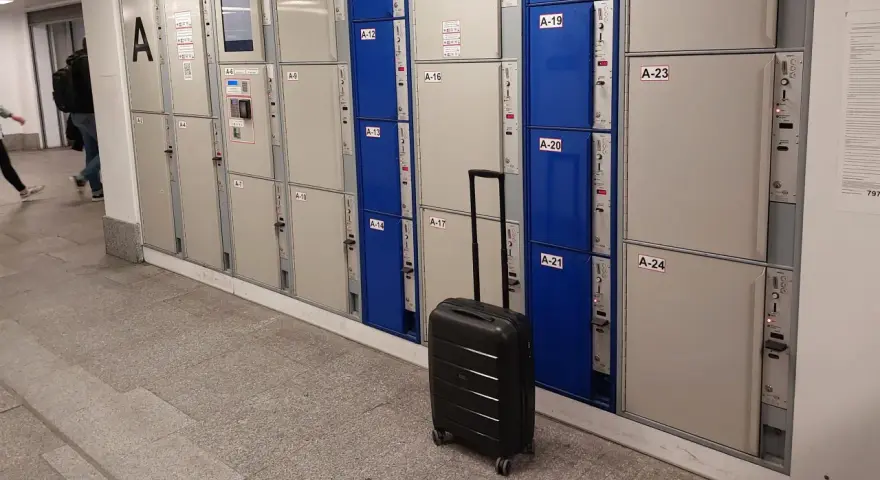Srebrna walizka czeka przy rzędzie szafek, idealne miejsce na przechowalnia bagażu Warszawa Centralna.