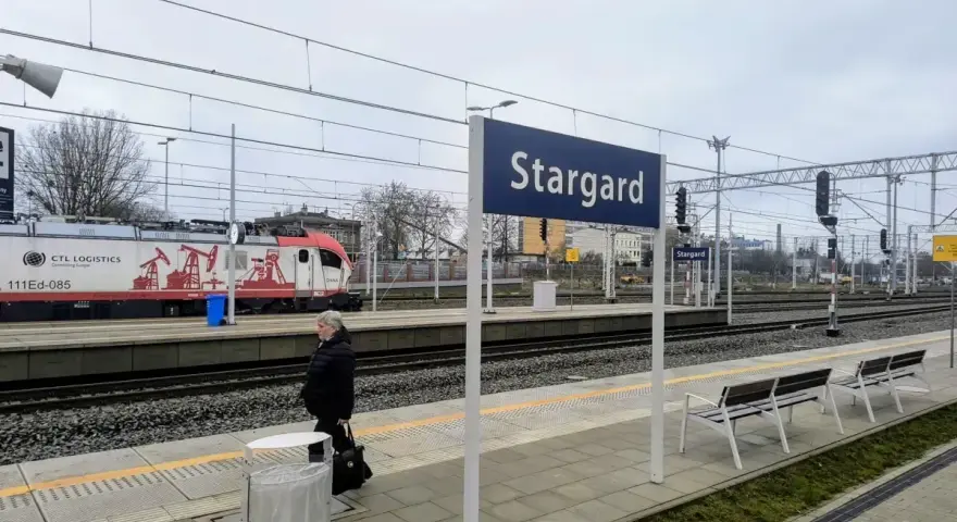 Kobieta czeka na peronie w Stargardzie. W tle pociąg towarowy CTL Logistics.