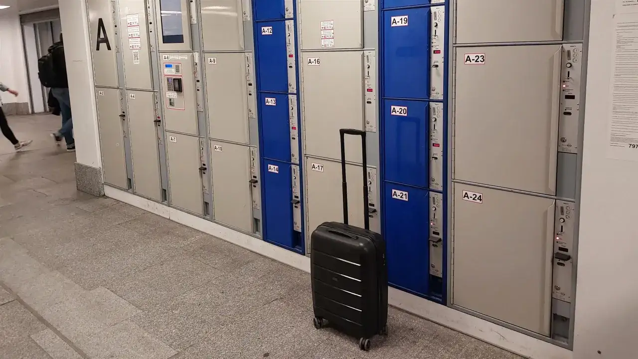 Przechowalnia bagażu Warszawa Centralna. Czarna walizka czeka obok rzędu szafek, gotowa do podróży.