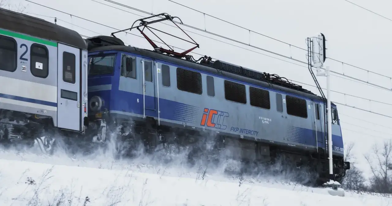 Pociąg PKP Intercity w zimowej scenerii, pędzący przez śnieg. Zastanawiasz się, ile kosztuje bilet do Berlina?